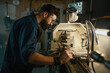 © Nomad_Soul - Serviceman working on turning lathe to adjust spare parts