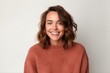 © Robert MEYNER - Portrait of a smiling young woman in sweater on white background.