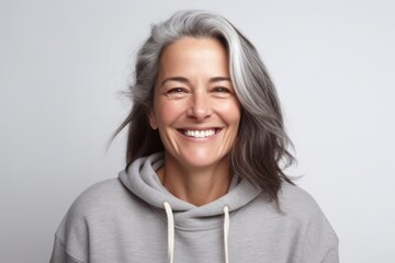 Portrait of a smiling mature woman in a gray hoodie.