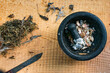 © Andrew Kornylak - herbs, a garlic filled black molcajete and a rustic knife on a wood board