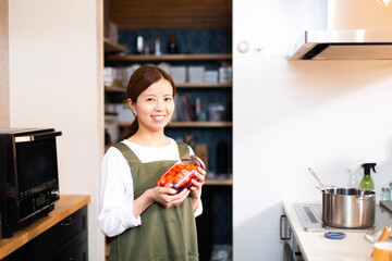 Wall Mural - 若い日本人女性、エプロンの主婦、キッチンでポートレート