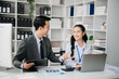 © laddawan - Asian business colleague business presents and explains and using laptop and tablet. Teamwork, financial marketing team, while sitting in office room.