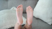 Closeup Of Girl Barefeet As She Lying On Couch At Home In Natural Light. High Quality 4k Footage