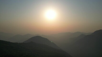 Wall Mural - Aerial view of mountain peak and sunset colorful sky from above from drone