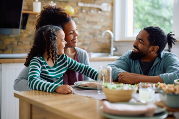 Wall Mural - Happy black family enjoying in conversation at dining table.