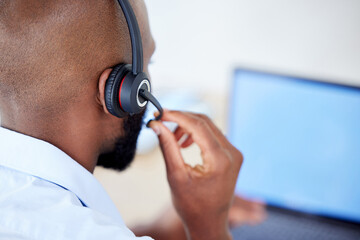 Wall Mural - Consultant, back view of black man with headset and laptop at his desk for support. Telemarketing or customer service, online communication or networking and African male call center agent at work