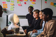 © Maskot - Smiling multiracial students looking at illuminated modern robot in innovation lab