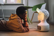 © Maskot - Cheerful boy in front of illuminated AI robot while lying on floor in innovation lab