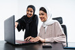 © oneinchpunch - Arabic muslim adult female businesswomen working together in the office in Dubai