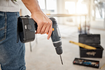 Drill, handyman and hand of a man at construction site for maintenance or carpenter work. Back of male engineer, constructor or contractor worker with electric power tools in building for renovation