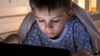 © Kyrylo Ryzhov - Little boy lying in bed with tablet computer and watching video. Children education, development, kids using gadgets secrecy, privacy