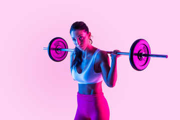 Wall Mural - Sportive woman training on a colorful background - Athletic fit adult female doing functional training fitness workout in a studio