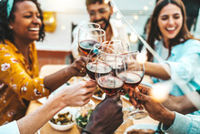 People Clinking Red Wine Glasses On Rooftop Dinner Party - Happy Friends Eating Meat And Drinking Wineglass At Restaurant Patio - Food And Beverage Lifestyle Concept With Guys And Girls Dining Outdoor