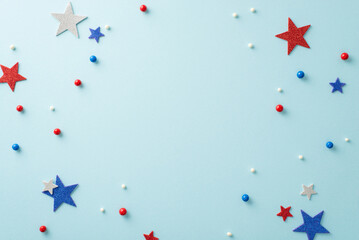 Wall Mural - Create a star-spangled spectacle on your table this Fourth of July! Top view of patriotic elements like round sprinkles and glitter stars on pastel blue surface. Space available for text or promotions