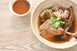 boiled duck meat in black soybean soup in bowl dipping spicy chili sauce 