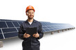 © Ljupco Smokovski - Technician in a uniform with a helmet and goggles holding a clipboard at a photovoltaic field