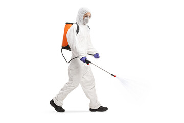 Wall Mural - Pest professional in a hazmat suit walking and spraying a sanitizer