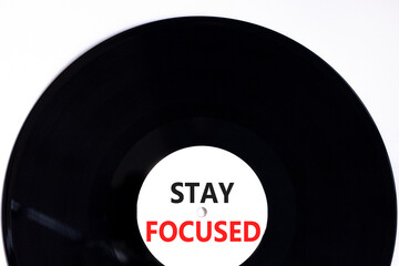 Stay focused symbol. Concept words Stay focused on beautiful black vinyl disk on a beautiful white table white background. Business, support, motivation, psychological stay focused concept. Copy space