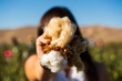 © Andrew Kornylak - A woman, face obscured, holding a boll of naturally colored cotton in a field, closeup