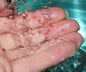 Wall Mural - Water drops falling onto female hand