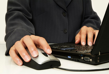 Corporate person using laptop & mouse close up