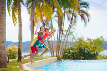 Wall Mural - Kids jump into swimming pool. Summer water fun.