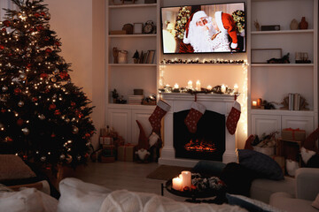 Wall Mural - TV set with Christmas movie above fireplace in cosy room. Winter holidays atmosphere