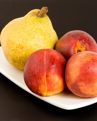 Wall Mural - Necterines and a pear set against a plain background