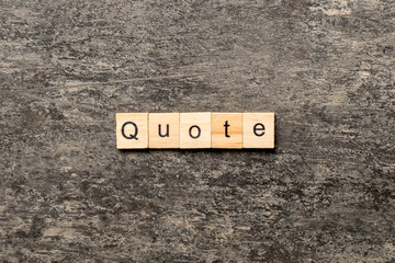 Quote word written on wood block. Quote text on cement table for your desing, concept