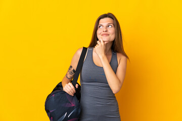 Slovak sport woman with sport bag isolated on yellow background and looking up