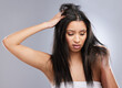 Hair, damage loss and woman in studio with worry for split ends, haircare crisis and weak strand. Beauty, hairdresser and face of female person with frizz, texture and dry problem on gray background