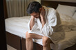© Viacheslav Yakobchuk - Dejected man is sitting on large bed in hotel room