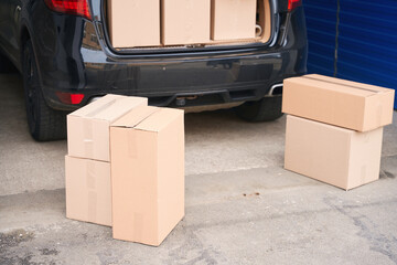 Wall Mural - Car with cardboard boxes in the trunk in a warehouse with self-storage unit