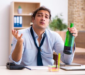 Poster - Young male employee drinking alcohol at workplace