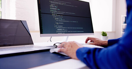 Computer Programmer Writing Program Code On Computer