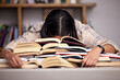 Study books, fatigue and woman student at desk with textbook for test feeling overworked. Stress, female person and home studying for university exam and course with burnout and sleeping in a house