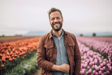 Medium Shot Portrait Photography Of A Grinning Man In His 30s That Is Wearing A Chic Cardigan Against A Flower Field Or Tulip Field Background . Generative AI