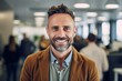 © Hanne Bauer - Portrait of a handsome young man smiling at the camera while standing in a modern office