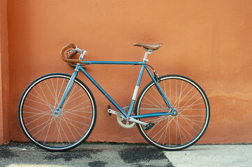 Retro fixed gear bicycle on brown concrete wall background