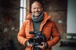 © Anne-Marie Albrecht - Portrait of a smiling mature male videographer with professional camera.