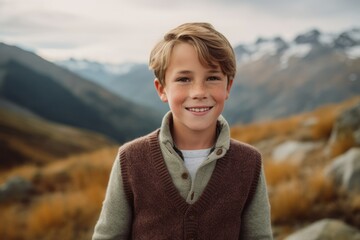 Wall Mural - Portrait of smiling boy looking at camera while standing on mountain top