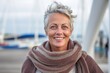 © Anne-Marie Albrecht - Medium shot portrait photography of a satisfied woman in her 50s that is wearing a chic cardigan against a dramatic sailboat race on a windy day background . Generative AI