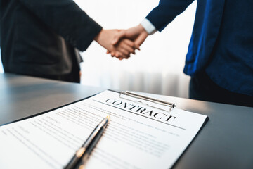 Wall Mural - Focus closeup panorama business contract paper with pen, while two professionals shake hand in blurred background, signifying successful negotiation and partnership agreement with handshaking. Prodigy