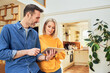 © baranq - Mid adult couple at home planning new interior design with digital tablet