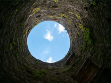 Stone Well Hole, Old Construction From Inside, Brick Walls And Blue Sky Background, Fall Down In The Well Concept