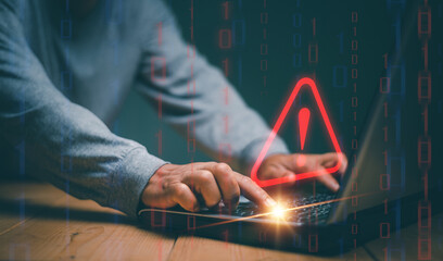 Businessman using computer laptop with triangle caution warning sign for notification error and maintenance concept, cyber security, hacker attacks and hacking data, Ransomware, Phishing, Spyware.