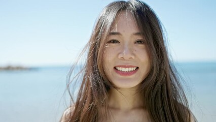 Wall Mural - Young chinese woman smiling confident standing at seaside