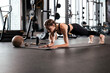 © ty - Portrait of a muscular woman on a plank position at gym.