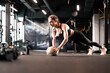 © ty - Fit and muscular woman exercising with medicine ball at gym.