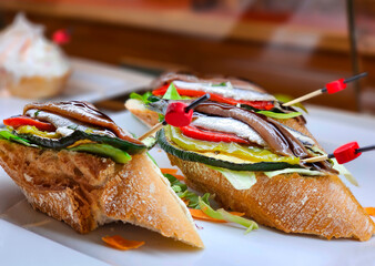 Sticker - Appetizing spanish tapas with anchovies and green vegetables with wooden skewers on white tray closeup in Marbella, Costa del Sol, Spain